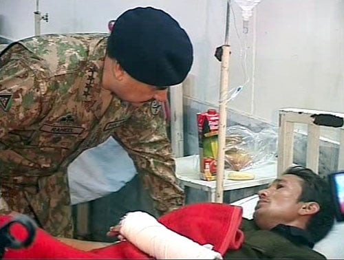 Army chief visiting an injured patient at the DHQ in Charsadda