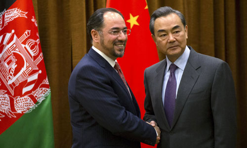 Afghanistan´s Foreign Minister Salahuddin Rabbani, left, shakes hands with Chinese Foreign Minister Wang Yi.—Reuters photo