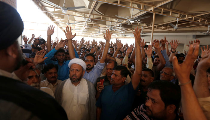 Mourners raise their hands and shout slogans during the funeral.—Reuters photo