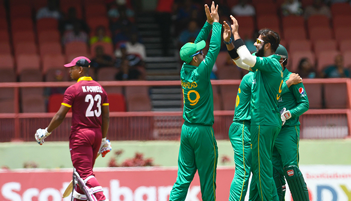 Ahmed Shehzad (C) and Imad Wasim (R) of Pakistan celebrate the dismissal of Kieran Powell (L) of the West Indies during the 3rd and final ODI match between West Indies and Pakistan - AFP