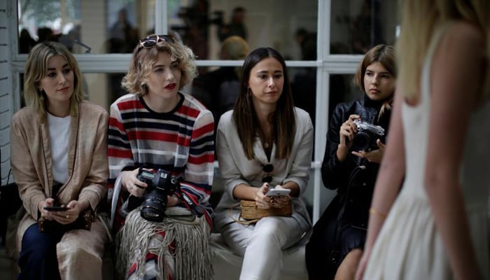 Audience members hold cameras as they watch a model pass by during a show by the Australian fashion house Albus Lumen. REUTERS/Jason Reed