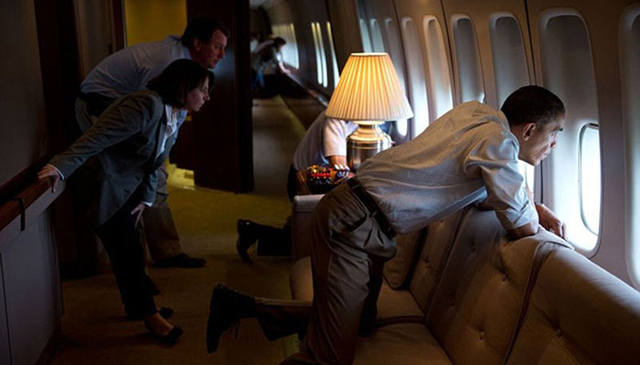 May 26, 2013. The President and members of the White House staff look out the window of Air Force One to view tornado damage over Moore, Oklahoma. After landing at Tinker Air Base, the President did a walking tour of the damage and met with those affected