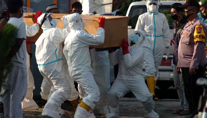 Local disaster mitigation agency personnel in personal protective equipment (PPE) carry the coffin of a person who passed away due to coronavirus disease (COVID-19) during a funeral in Tegal, Central Java province, Indonesia, June 30, 2021, in this photo taken by Antara Foto .— AFP