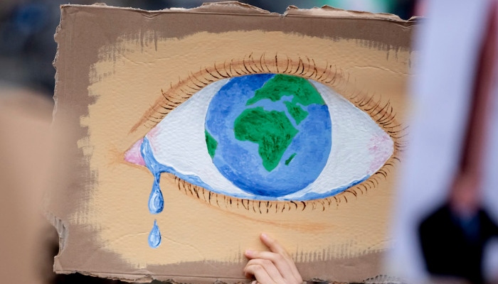 A protester holds up a poster depicting the Earth as a crying eye during a demonstration in Berlin on March 22. (Christoph Soeder/AFP/Getty Images.