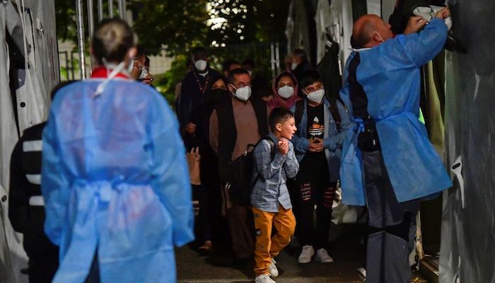 People who were evacuated from Kabul, Afghanistan walk towards a tent to undergo coronavirus disease (COVID-19) testing after arriving in Doberlug-Kirchhain, Germany, August 20, 2021. Photo: Reuters