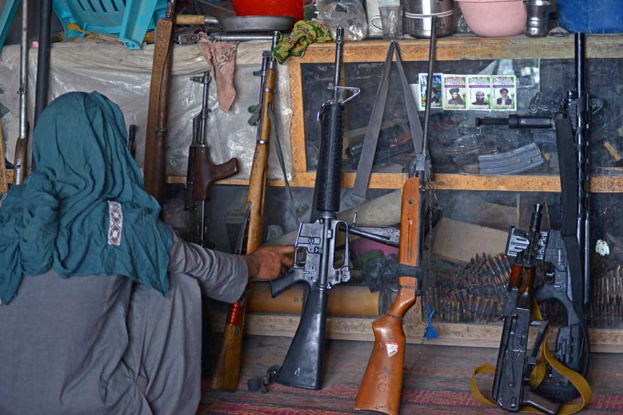 An Afghan vendor displays guns for sale as he waits for customers in his shop at a market in Panjwai district of Kandahar province on September 4, 2021. — Javed Tanveer/AFP