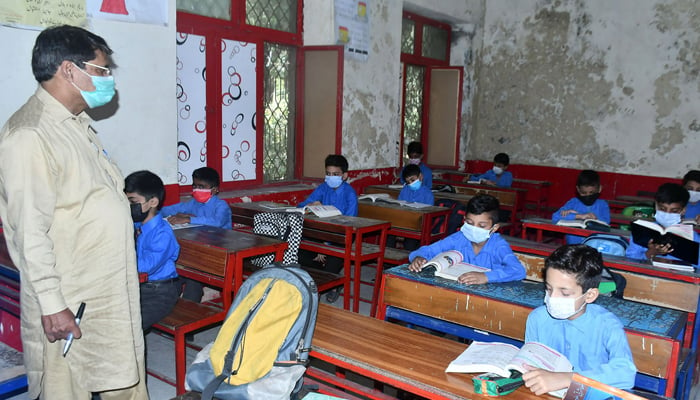 Students wearing facemasks as they attend class at a school in Lahore, on September 16, 2021. — ONLINE/File