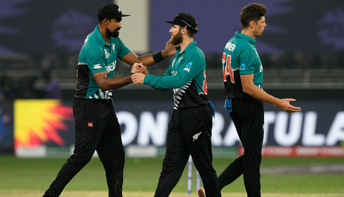 New Zealand´s captain Kane Williamson (C) celebrates with teammates Ish Sodhi (L) and Mitchell Santner at the end of the ICC Twenty20 World Cup cricket match between New Zealand and Scotland at the Dubai International Cricket Stadium in Dubai on November 3, 2021. — AFP