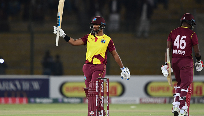 West Indies captain Nicholas Pooran (L) celebrates after scoring a half-century (50 runs) as his teammate Darren Bravo walks past during the third Twenty20 international cricket match between Pakistan and West Indies at the National Stadium in Karachi on December 16, 2021. — AFP