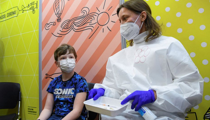 Noah, 10, sits next to a health worker at a children vaccination centre against the coronavirus (COVID-19) pandemic at the citys town hall Rotes Rathaus, in Berlin, Germany December 23, 2021. — Reuters/File