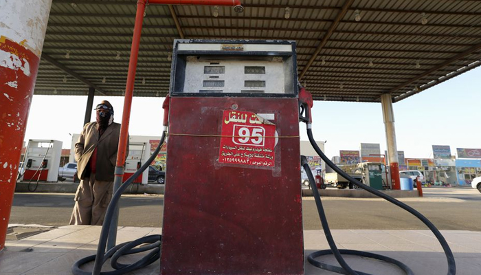 A fuel pump assistant stands next to an old fuel pump during the early hours near the village of Salwa at the Qatari-Saudi border, south of the eastern provience of Khobar, Saudi Arabia January 29, 2016. — Reuters/File