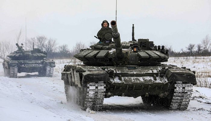 Russian servicemen drive tanks during military exercises in the Leningrad Region, Russia, in this handout picture released February 14, 2022. — Russian Defence Ministry/Handout via Reuters