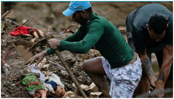 People lift rubble to look for survivors in a mudslide in Petropolis, Brazil on February 16, 2022 — Carl de Souza/AFP