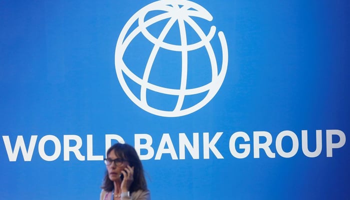 A participant stands near a logo of World Bank at the International Monetary Fund - World Bank Annual Meeting 2018 in Nusa Dua, Bali, Indonesia, October 12, 2018. — Reuters/File