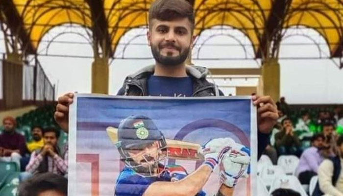 A fan holding a picture of Virat Kohli during the seventh edition of Pakistan Super League (PSL) at the Gaddafi Stadium Lahore. — Twitter