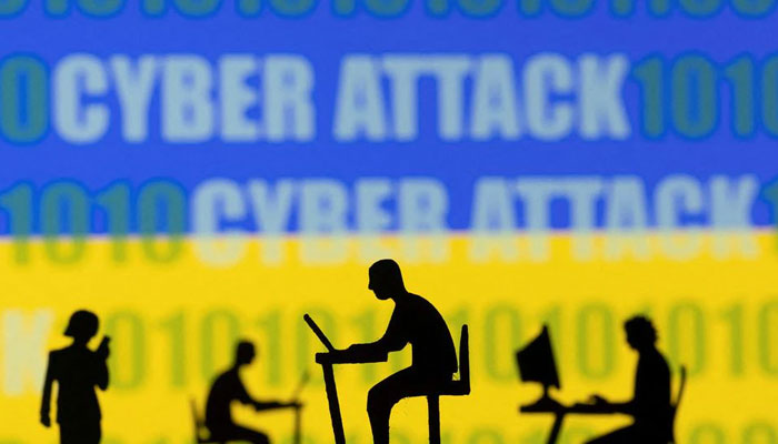 Figurines with computers and smartphones are seen in front of the words Cyber Attack, binary codes and the Ukrainian flag, in this illustration taken February 15, 2022. — Reuters/File