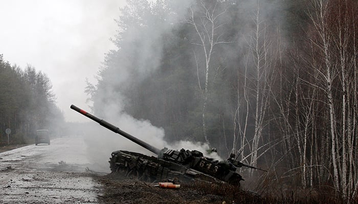 Smoke rises from a Russian tank destroyed by the Ukrainian forces on the side of a road in Lugansk region on February 26, 2022. — AFP