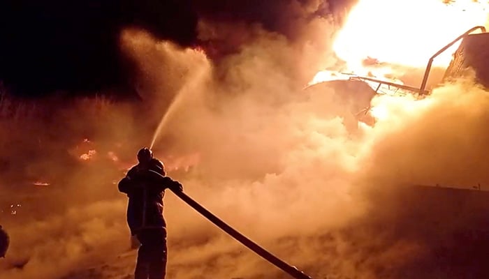 Fire fighters extinguish fire in an oil depot that Ukraines State Emergency Services say was caused by Russian strikes in Zhytomyr region, Ukraine March 7, 2022 in this still image obtained from a handout video. — Reuters