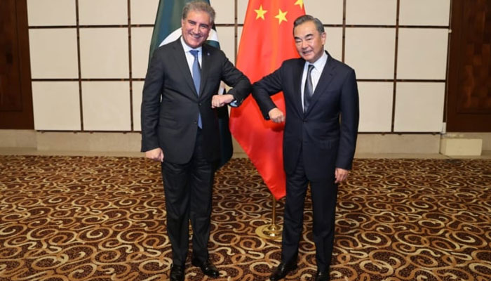 Foreign Minister Shah Mahmood Qureshi and Chinese FM Wang Yi greet each other in the Hainan province of China. — Foreign Office/File