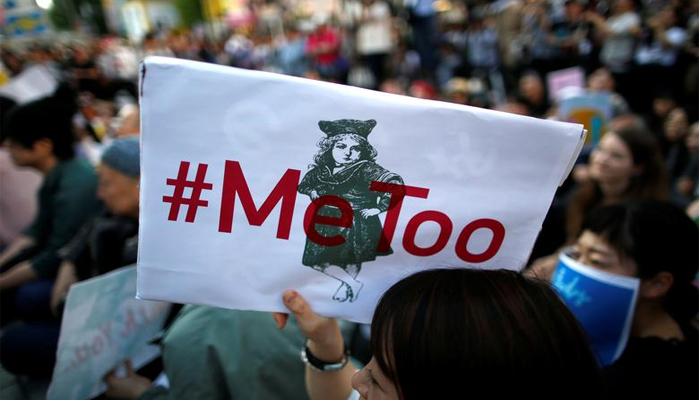 A protester raises a placard reading #MeToo during a rally against harassment at Shinjuku shopping and amusement district in Tokyo, Japan, on April 28, 2018.