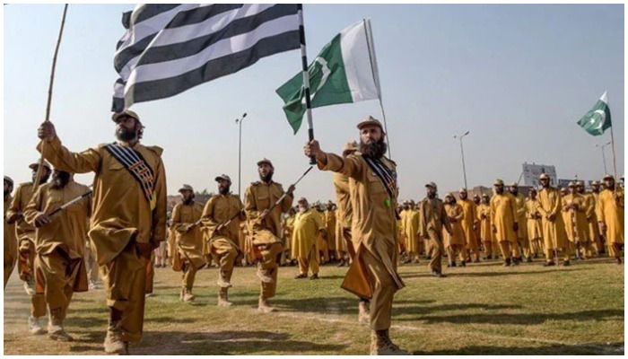 Jamiat Ulema-e-Islam (JUI) activists hold the Pakistani and their party flags as they prepare for Azadi March in Peshawar on October 13, 2019.—AFP/File