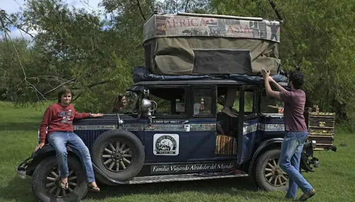 Argentinian Zapp family members open a tent on the ceiling of their car, a 1928 Graham-Paige, near Gaualeguaychu, Entre Rios province, Argentina, on March 10, 2022. — AFP