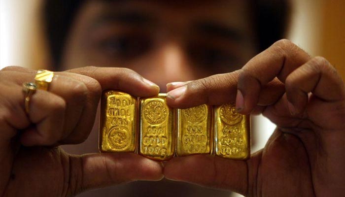 A person is displaying gold bars. — Reuters/File