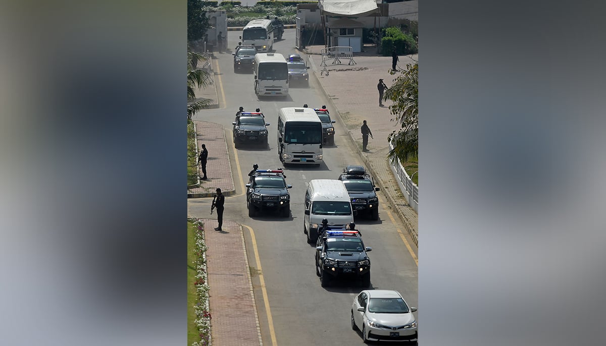 Security personnel escort a convoy carrying Australias and Pakistani players for the practice session on the eve of their second cricket Test match at the National Cricket Stadium in Karachi on March 11, 2022. — AFP