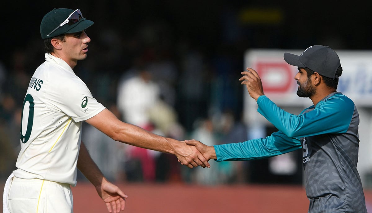 Australias captain Pat Cummins (L) shakes hands with his Pakistans counterpart Babar Azam after their win in the third and final Test cricket match between Pakistan and Australia at the Gaddafi Cricket Stadium in Lahore on March 25, 2022. — AFP