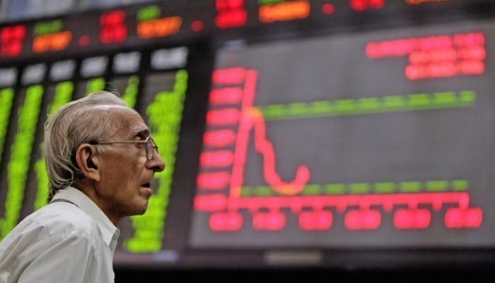 A worried investor looks at the digital stock board at the Pakistan Stock Exchange. — AFP/File