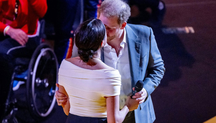 Prince Harry and Meghan Markle kiss at the opening ceremony of the Invictus Games in The Hague on April 16, 2022- AFP