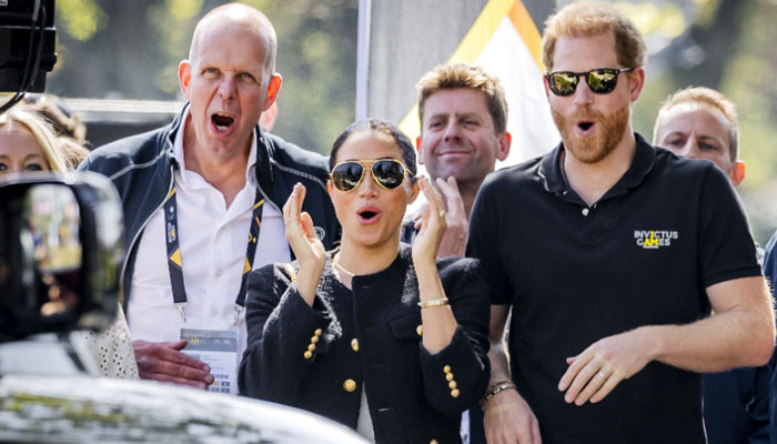 The Duke and Duchess of Sussex, Prince Harry (R) and his wife, Meghan Markle (C) look on as participants compete in The Invictus Games in The Hague on April 16, 2022- AFP