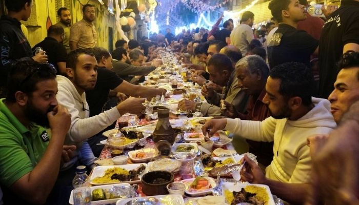 Residents of Ezbet Hamada gather to eat during Iftar, a meal to end their fast at sunset, during the holy fasting month of Ramadan in Mataria, Cairo, Egypt, April 16, 2022. Reuters