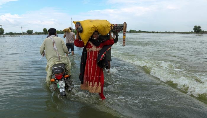 Flood affectees can be seen taking belonging as provinces reel from flash floods. — AFP/File