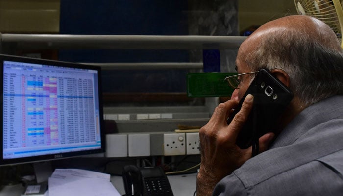 A stock broker can be seen speaking on call during a trading session. — AFP/File