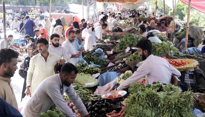 People are buying vegetables at a stall at weekly bazar located on Shadman area in Lahore on Sunday, October 02, 2022. — PPI/File