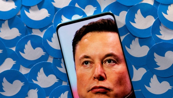 An image of Elon Musk is seen on a smartphone placed on printed Twitter logos in this picture illustration taken April 28, 2022. — Reuters