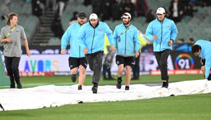 The ground staff runs to cover the pitch area as the ICC men´s Twenty20 World Cup 2022 cricket match between Australia and England is being announced abandoned because of rain at Melbourne Cricket Ground (MCG) on October 28, 2022, in Melbourne.— AFP