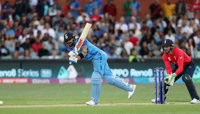 Indias Virat Kohli plays a shot watched by Englands wicketkeeper Jos Buttler (R) during the ICC mens Twenty20 World Cup 2022 semi-final cricket match between England and India at The Adelaide Oval on November 10, 2022 in Adelaide. — AFP