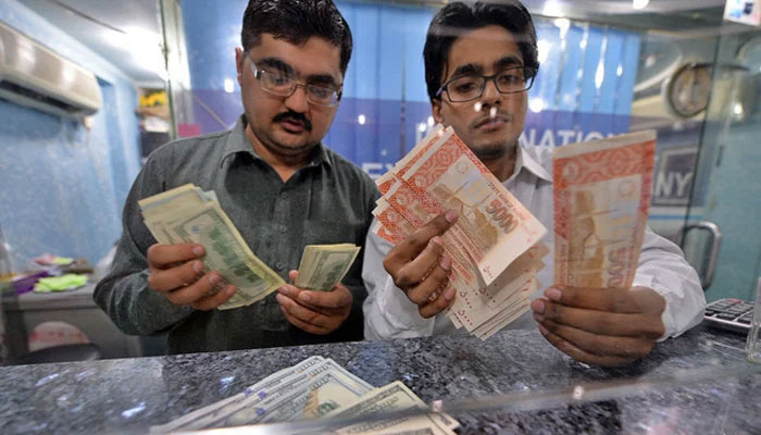 Moneydealers count rupees and dollars at an exchange company. — Reuters/File