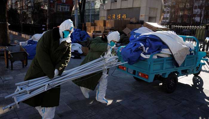 Pandemic control workers in protective suits unload tent poles as they dismantle structures in a neighbourhood that used to be under lockdown, as coronavirus disease (COVID-19) outbreaks continue, in Beijing, China December 10, 2022. — Reuters