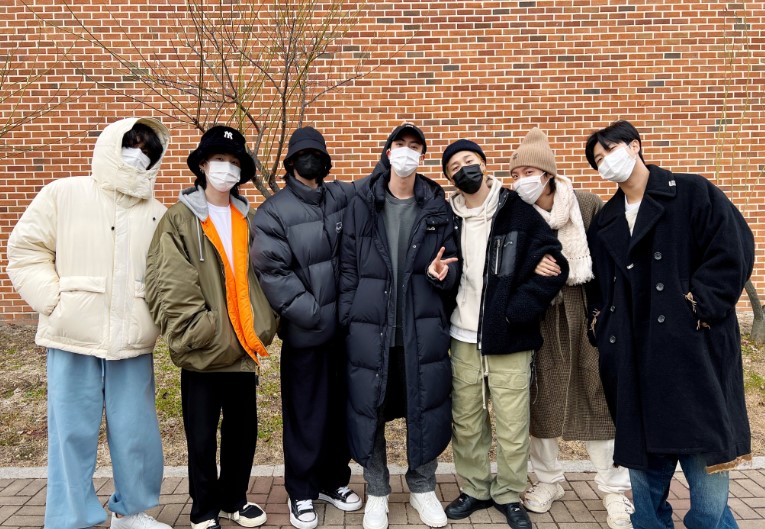 BTS members pose for pictures as Jin leaves for military duty