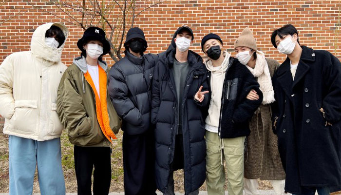 BTS members pose for pictures as Jin leaves for military duty