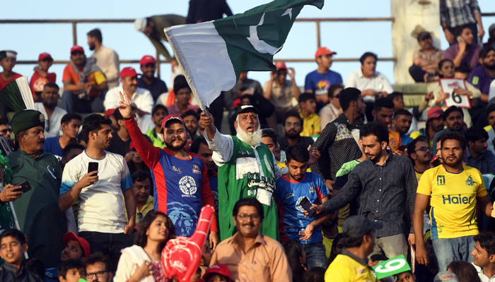 Cricket fans wave the national flag during PSL final match between Peshawar Zalmi and Islamabad United in Karachi. —AFP/File