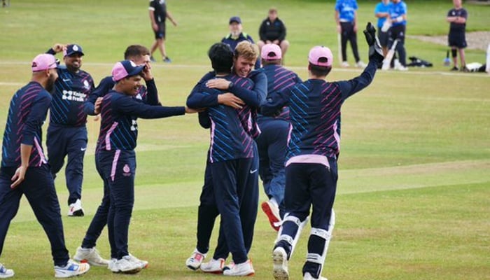 Players of the Middlesex County Cricket Team celebrate on the cricket pitch. — Middlesex Cricket website