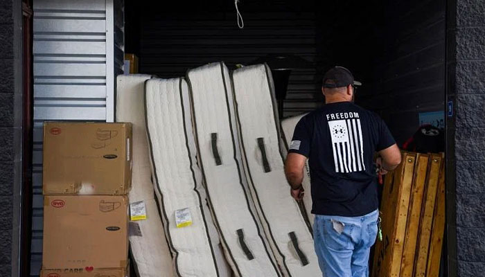 An undated image of a warehouse worker unloading mattresses. — Reuters/File