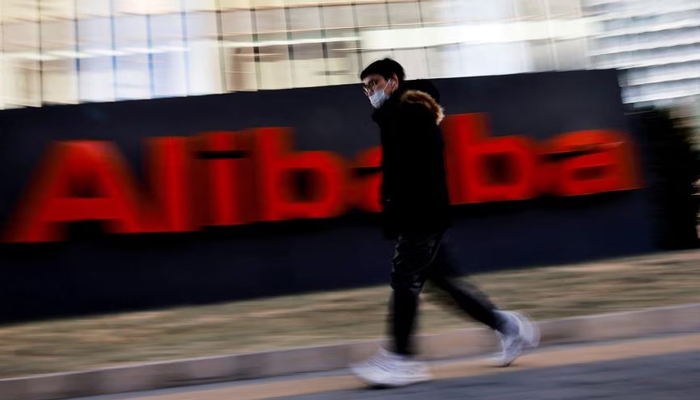 A person walks by the Alibaba Group logo in front of its office in Beijing, China Jan. 5, 2021. — Reuters