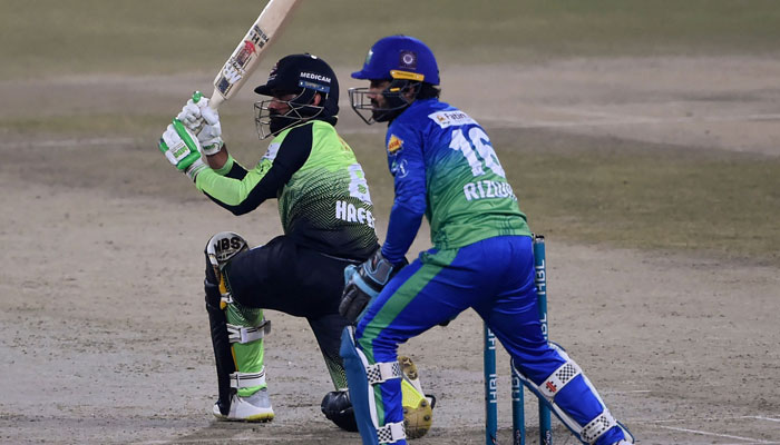 Lahore Qalandars Mohammad Hafeez (L) plays a shot as Multan Sultans captain wicket-keeper Mohammad Rizwan watches during the PSL T20 final cricket match between Lahore Qalandars and Multan Sultans at the Gaddafi Cricket Stadium in Lahore on February 27, 2022. — AFP