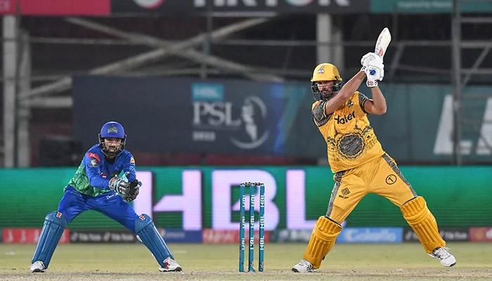 A Peshawar Zalmi batter hits a shot as Mohammad Rizwan looks on at National Stadium, Karachi, on February 5, 2022. — PCB