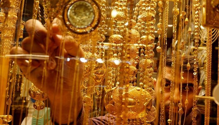 A goldsmith arranges jewellery at his shop. — Reuters/File